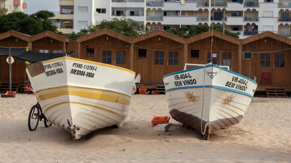 Colorful fishing boats resting on sandy Monte Gordo beach, Faro, Portugal.
